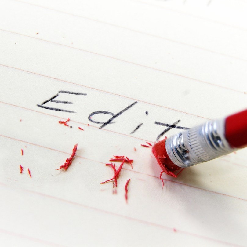 pencil erasing a word on lined paper